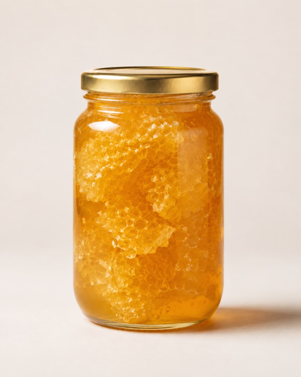 Jar of golden honey packed with real honeycomb